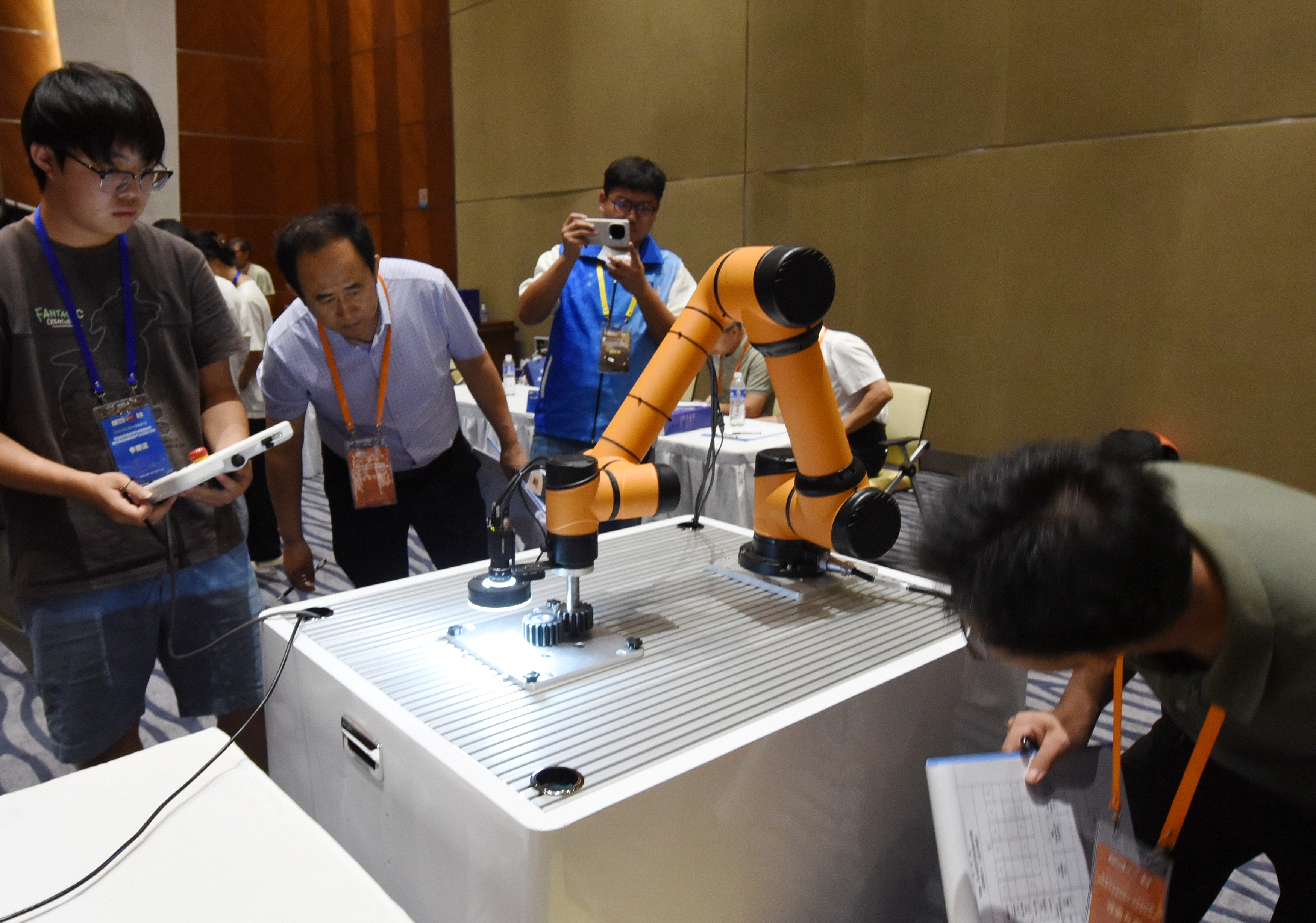 2025年中國(guó)大學(xué)生機(jī)械工程創(chuàng)新創(chuàng)意大賽智能精密裝配賽京津冀魯聯(lián)賽現(xiàn)場(chǎng)，評(píng)委對(duì)參賽選手進(jìn)行實(shí)操調(diào)試評(píng)比。